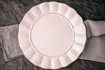 White plate on the dark stone table top view
