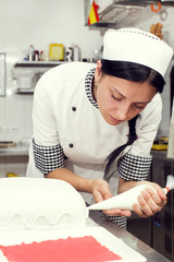 pastry chef decorates a cake in a candy store