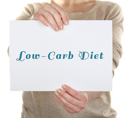 Woman holding card with text Low-Carb Diet, close-up