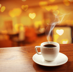 Cup of coffee on table on blured cafe background