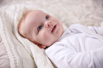 Portrait of adorable smiling baby on the floor, close up