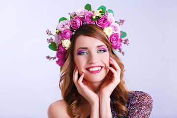 Obraz na płótnie Canvas Beautiful young woman wearing floral headband on a grey background