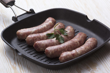raw sausages on a  pan,  wooden background