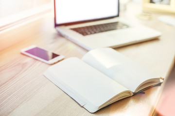 Workplace business still life. Workplace blogger. Notebook, laptop, mobile phone, pen, window. Film effect.