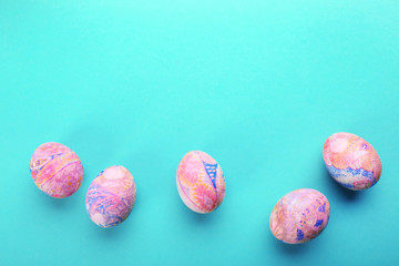 Easter eggs on a blue table, top view