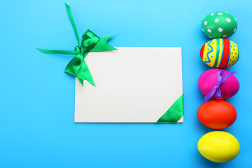 Easter eggs with greeting card on blue background