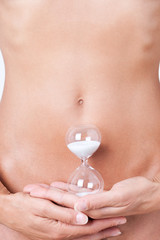 ventre de femme avec un sablier