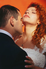 grom huging kissing bride with red hair outdoors Lviv