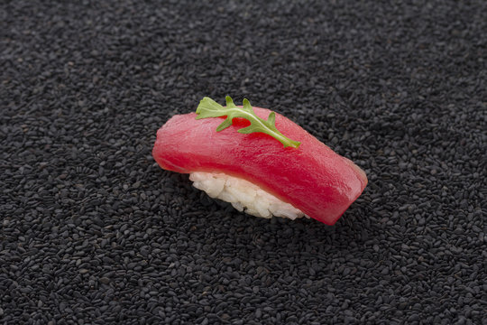 Tuna sushi nigiri on black sesame background