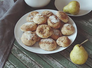 Biscuit cookies and pears. Cookies on white plate on wooden tabl