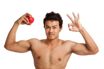 Muscular Asian man show OK with red apple