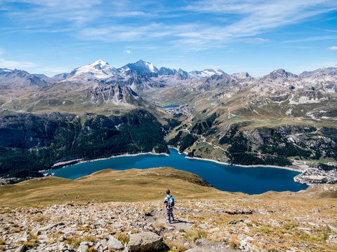 Hiker on mountain peak looking at distant lake