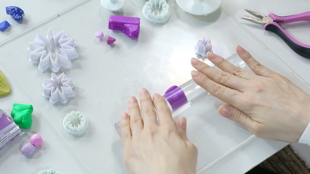 Artist makes Polymer Clay jewelry, artist at work. Workshop. Hobby &ndash; Art Clay Modeling. Tools for modeling. Handmade Production. Plasticine. Hands using the template stamp (preform).