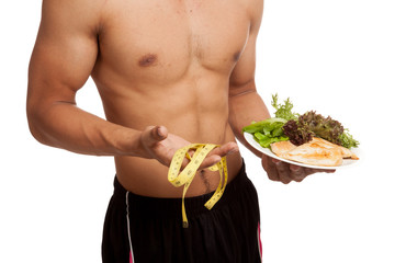 Muscular Asian man diet with clean food and measuring tape