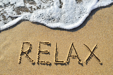 Sea surf and the word relax on the sand