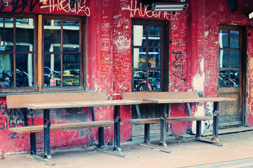 Street cafe in Amsterdam with graffiti on the shabby wall