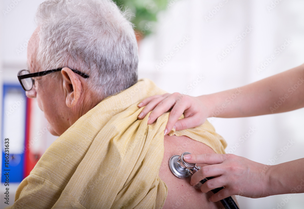 Wall mural Nurse  listening heartbeat of old man