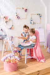Little sisters of the artist in a floral studio