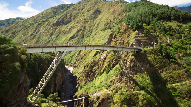 Experience the breathtaking time lapse of a group of adventurous tourists gathering for bungee jumping over the iconic San Francisco Bridge in Baños,Ecuador.