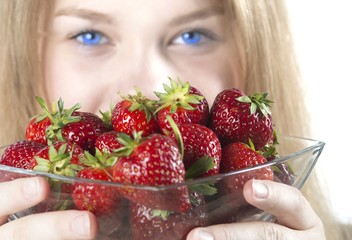 Blonde Jugendliche mit stechend blauen Augen mit Erdbeeren