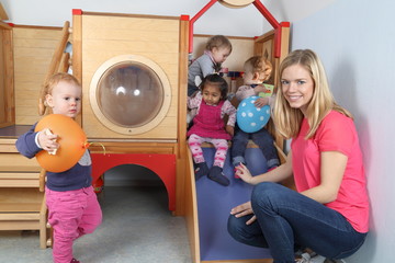 Erzieherin mit 4 Kindern an Spielgerät 2 - obrazy, fototapety, plakaty