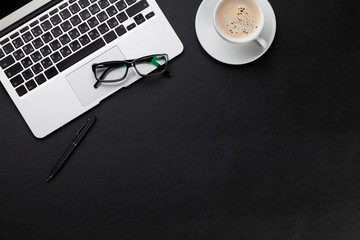 Office desk with laptop and coffee cup