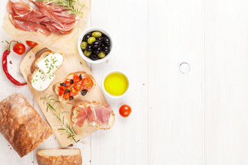 Bruschetta with cheese, tomatoes and prosciutto