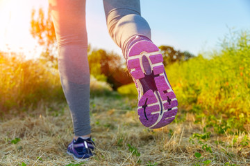 Woman running at sunset in a field