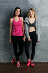 Portrait of two beautiful sporty girls looking at camera and smiling