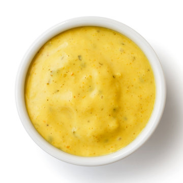 Small condiment bowl of yellow curry sauce. Isolated from above.