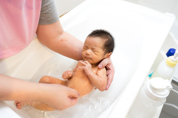 Asian newborn baby having a bath