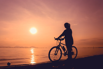 Silhouette of healthy biker-girl enjoying the view at seaside