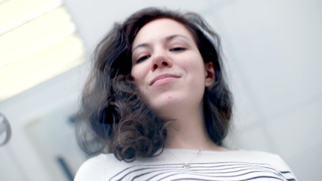 Beautiful young girl puts print stamp on office glass table. shoot from below