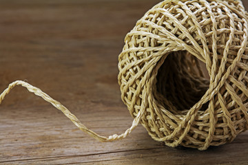 Ball of string with texture and strands on a wooden background,