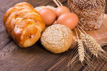 Assortment of baked bread on wooden table background