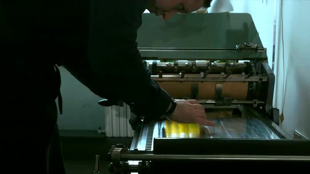 Caucasian male preparing stamp for a letterpress print. Dolly out 4k 60 FPS. Shot with Blackmagic URSA Mini