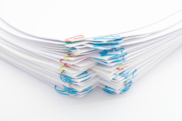 Step pile of paperwork with colorful paperclip