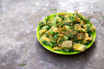 Thai Cuisine; cha-om omelet in green plate