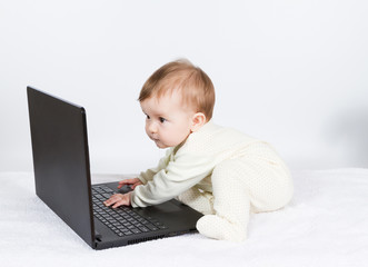 Cute baby boy with black laptop