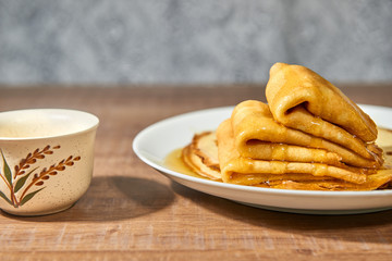 Pancakes with honey on white plate.