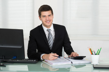 Obraz premium Happy Businessman Calculating Bill