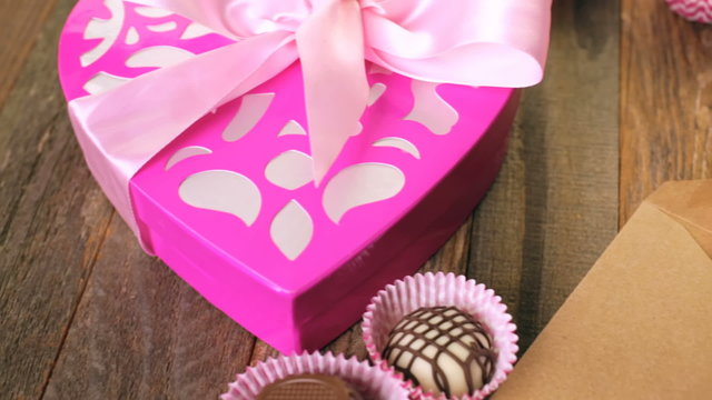 Chocolates in heart shaped box on rustic wood table