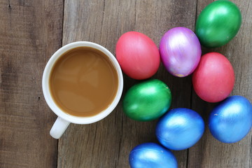Easter eggs and Coffee cup on wood background.