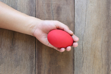 Easter eggs in hand on wood background.