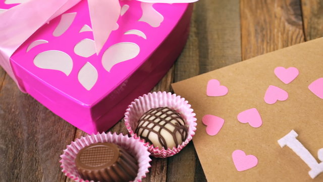 Chocolates in heart shaped box on rustic wood table