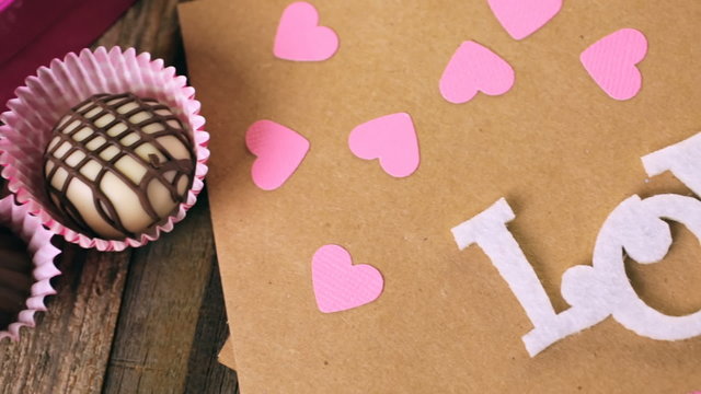 Chocolates in heart shaped box on rustic wood table