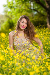 Naklejka na ściany i meble Beautiful young girl among yellow flowers