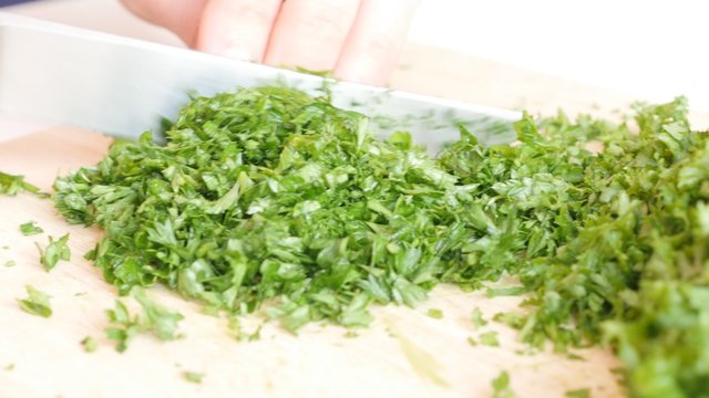 Cutting parsley plant on smaller pieces 4K 3840X2160 UltraHD footage - Petroselinum crispum plant cut on cutting board 4K 2160p UHD video 