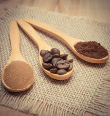 Grains, ground and instant coffee with wooden spoon on jute canvas