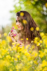 Naklejka premium Beautiful young girl among yellow flowers